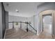 Upstairs hallway with arched doorway and black railing at 17809 Sandpine Trace Way, Tampa, FL 33647