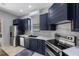 Modern kitchen featuring navy cabinets, stainless steel appliances, and quartz countertops at 17809 Sandpine Trace Way, Tampa, FL 33647