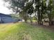 This backyard has a brick fire pit, green grass, and tall trees at 17933 Eagle Ln, Lutz, FL 33558