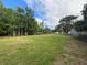 Large grassy backyard lined with trees and fencing at 17933 Eagle Ln, Lutz, FL 33558