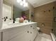 Bathroom with double sinks, stylish wood-look tile wall, and white cabinetry at 17933 Eagle Ln, Lutz, FL 33558