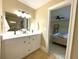 Bright bathroom with double vanity, tile floors, and an open door to the bedroom at 17933 Eagle Ln, Lutz, FL 33558