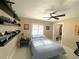 Bedroom features a ceiling fan, window, dark shelving, and ensuite walk-in closet at 17933 Eagle Ln, Lutz, FL 33558