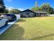 Well-kept home with a large front yard, a driveway with parked cars, and mature trees at 17933 Eagle Ln, Lutz, FL 33558