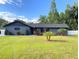 Charming single-story home with a well-maintained lawn, mature trees, and black trim at 17933 Eagle Ln, Lutz, FL 33558