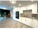 Modern kitchen with white cabinets, stainless steel appliances and wood-look tile flooring at 17933 Eagle Ln, Lutz, FL 33558
