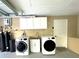 This garage features a full laundry room with washer and dryer, sink, water filtration and white cabinets at 17933 Eagle Ln, Lutz, FL 33558