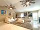 Inviting living room featuring large sectional sofa, ceiling fans, and bright artwork at 17933 Eagle Ln, Lutz, FL 33558