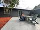 Outdoor patio with Adirondack chairs and firepit, on back of gray house with dark trim and sliding glass doors at 17933 Eagle Ln, Lutz, FL 33558