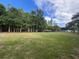 A large yard stretches to a stand of trees under a cloudy sky at 17933 Eagle Ln, Lutz, FL 33558