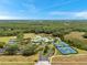 An aerial view showcases a pool, clubhouse, tennis courts, and recreational areas surrounded by a picturesque landscape at 19156 Dove Creek Dr, Tampa, FL 33647
