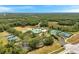 A sweeping aerial view shows a pool, clubhouse, tennis courts, and recreational fields surrounded by lush landscaping at 19156 Dove Creek Dr, Tampa, FL 33647