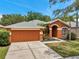Charming single-story home with an attached two-car garage, arched entryway, and lush landscaping for appealing curb appeal at 19156 Dove Creek Dr, Tampa, FL 33647