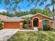 Lovely single-story home showcasing a two-car garage, stucco exterior, and an arched entryway at 19156 Dove Creek Dr, Tampa, FL 33647