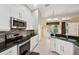 Bright kitchen features white cabinets, granite countertops, stainless steel appliances, and tiled backsplash at 19156 Dove Creek Dr, Tampa, FL 33647