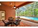 Covered patio featuring a dining table, ceiling fan, and screened-in pool with beautiful outdoor views at 19156 Dove Creek Dr, Tampa, FL 33647
