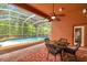 Covered patio with a ceiling fan, overlooking a screened-in pool and lush backyard, ideal for outdoor dining at 19156 Dove Creek Dr, Tampa, FL 33647