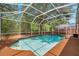 A screened-in pool with clear blue water, surrounded by a deck and lush greenery, offering a private oasis at 19156 Dove Creek Dr, Tampa, FL 33647