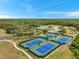 An aerial shot of tennis courts showcases manicured landscaping and a clubhouse in the background at 19156 Dove Creek Dr, Tampa, FL 33647