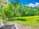 Spacious backyard with lush green grass, tall trees and a waterfront view at 2014 Hampstead Cir, Sun City Center, FL 33573