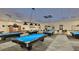 A spacious billiard room offers several tables and overhead lighting for fun and relaxation at 2014 Hampstead Cir, Sun City Center, FL 33573