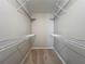 Walk-in closet with carpeted floor, wire shelving and rod on both sides for optimal storage solutions at 2014 Hampstead Cir, Sun City Center, FL 33573