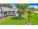 Exterior view of a home showcasing manicured lawn, shade trees and waterfront access at 2014 Hampstead Cir, Sun City Center, FL 33573