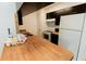Kitchen featuring butcher block countertops, black cabinets, and white appliances at 213 Red Cedar Pl # 213, Brandon, FL 33510