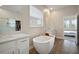 Bright bathroom with soaking tub, walk in closet, white vanities, and wood-look floors at 21648 Snowy Orchid Ter, Land O Lakes, FL 34637