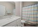 Bathroom with a white sink, vanity, and a bright, patterned shower curtain for a clean and modern look at 21648 Snowy Orchid Ter, Land O Lakes, FL 34637