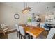 Dining area showcases a wooden table, elegant lighting fixture, and seamless access to the modern kitchen at 21648 Snowy Orchid Ter, Land O Lakes, FL 34637