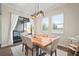 Dining area features a wooden table, pendant lighting, and natural light from the adjacent windows and glass door at 21648 Snowy Orchid Ter, Land O Lakes, FL 34637