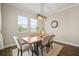 Bright dining area with a natural wood table, pendant lighting, and views of the lush greenery outside at 21648 Snowy Orchid Ter, Land O Lakes, FL 34637