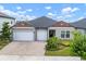 Inviting single-story home with three-car garage and meticulously landscaped front yard at 21648 Snowy Orchid Ter, Land O Lakes, FL 34637