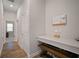 A hallway featuring wood floors, a built-in bench, a whiteboard and a view leading into a bedroom at 21648 Snowy Orchid Ter, Land O Lakes, FL 34637