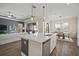 Open-concept kitchen with white countertops, stainless steel appliances, and seamless access to the living and dining areas at 21648 Snowy Orchid Ter, Land O Lakes, FL 34637