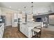 Open kitchen features quartz counters, an island with seating, stainless appliances, and wood floors at 21648 Snowy Orchid Ter, Land O Lakes, FL 34637