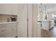 Bright kitchen features white cabinetry, a stainless steel coffee machine, and an island with a sink at 21648 Snowy Orchid Ter, Land O Lakes, FL 34637