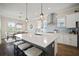 Kitchen with island featuring barstool seating, stainless appliances, quartz counters, and wood flooring at 21648 Snowy Orchid Ter, Land O Lakes, FL 34637