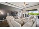 Cozy living room with a large sectional sofa, a TV, and sliding doors leading to a pool at 21648 Snowy Orchid Ter, Land O Lakes, FL 34637