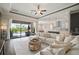 Bright, open living room with a large sectional sofa, and sliding glass doors to the pool area at 21648 Snowy Orchid Ter, Land O Lakes, FL 34637