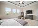 Spacious main bedroom showcasing a ceiling fan, large windows, and cozy seating at 21648 Snowy Orchid Ter, Land O Lakes, FL 34637