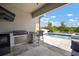 Outdoor kitchen and pool area featuring a built-in grill and bar seating with a lovely view at 21648 Snowy Orchid Ter, Land O Lakes, FL 34637