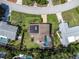 Aerial view showcases a home with solar panels and a screened pool in a lush, green neighborhood at 2287 Demaret Dr, Dunedin, FL 34698