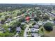 An aerial view of homes in a residential area surrounded by green trees, a golf course, and a nearby pond at 2287 Demaret Dr, Dunedin, FL 34698