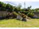 A tranquil backyard featuring a cozy chair, lush plants, and a well-maintained lawn at 2287 Demaret Dr, Dunedin, FL 34698