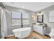 Modern bathroom featuring a soaking tub, separate vanity, and natural light at 2287 Demaret Dr, Dunedin, FL 34698