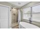 Well-lit bathroom with a standalone tub and a tiled shower with a shower curtain for privacy at 2287 Demaret Dr, Dunedin, FL 34698