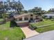 Captivating aerial view showcasing a home with stone accents, lush landscaping, and a driveway at 2287 Demaret Dr, Dunedin, FL 34698