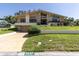 Beautifully landscaped front yard featuring a two-story home with stone accents and a charming front porch at 2287 Demaret Dr, Dunedin, FL 34698